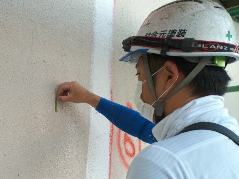 外壁の傷み具合を近くで確かめる職人
